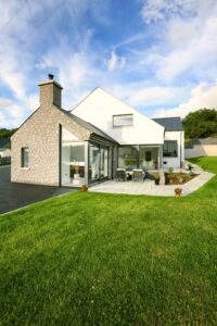 Contemporary extension with structural glazing and stone facade, set in rural setting – showing how modern glazing can integrate with traditional materials in planning-restricted areas.
